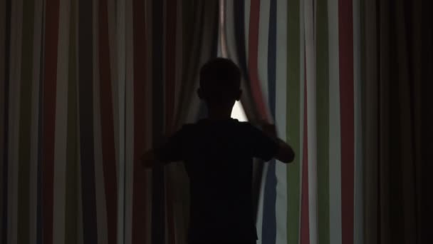 Мальчик открывает шторы — стоковое видео