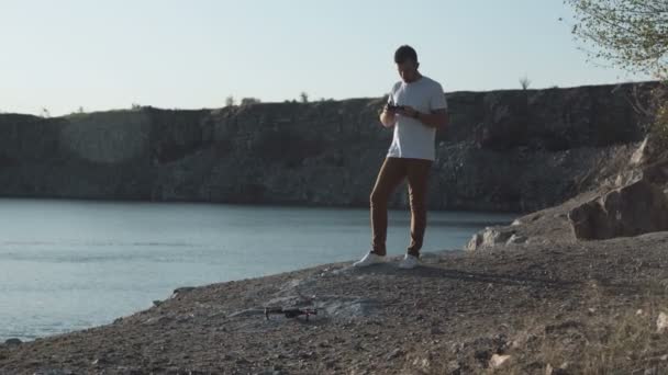 Человек, использующий дрон на берегу — стоковое видео