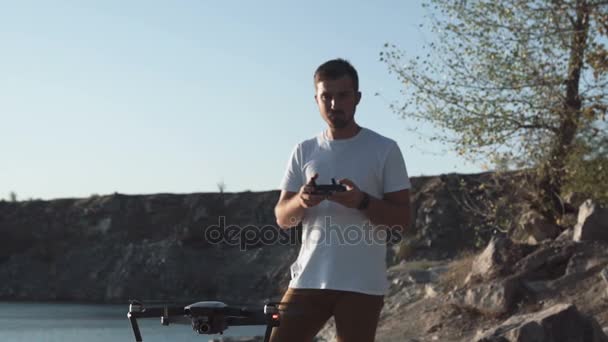 Man met drone op oever — Stockvideo