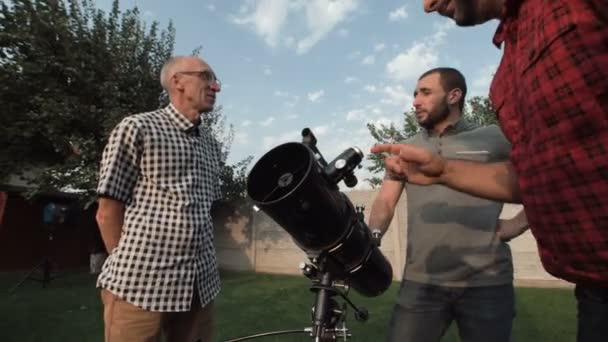 Männer beobachten Teleskop auf Hinterhof — Stockvideo
