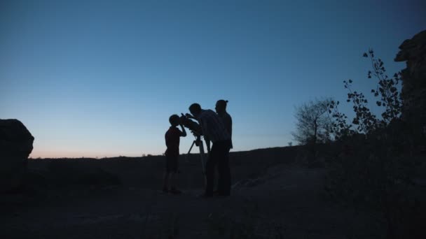 Personas en la costa mirando a través del telescopio — Vídeo de stock