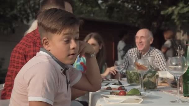 Скучный мальчик на вечеринке воссоединения — стоковое видео