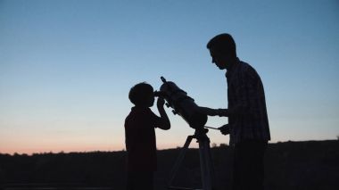 Adam ve çocuk teleskop kullanma