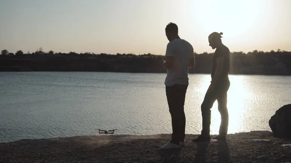 Mężczyźni na wybrzeżu kontrolowanie drone — Zdjęcie stockowe