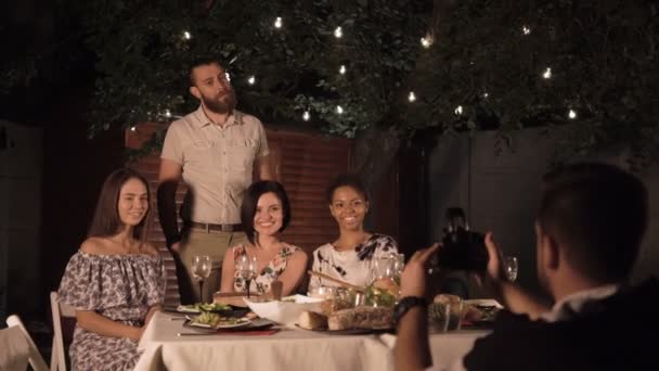 Amigos tomando fotos mientras cenan — Vídeo de stock