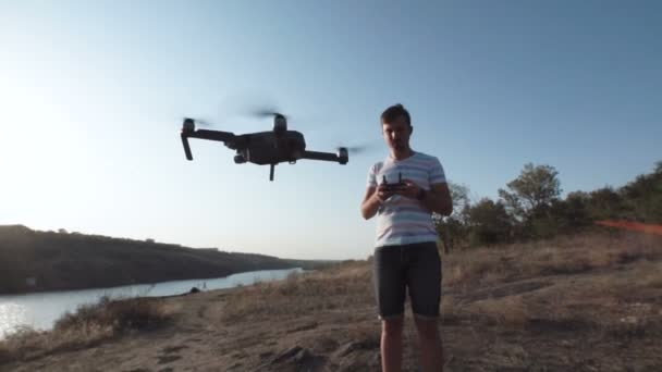 Hombre usando dron en la orilla — Vídeo de stock