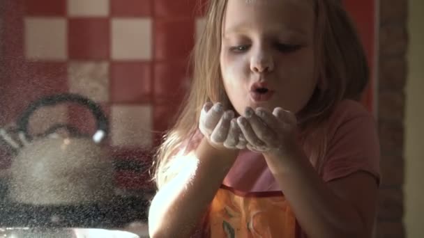 Jovem menina soprando farinha na cozinha — Vídeo de Stock