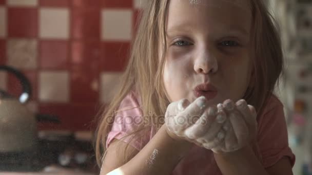 Молода дівчина дме борошно на кухні — стокове відео