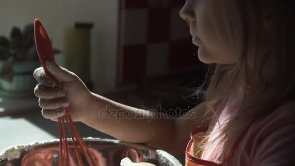 Meisje speelt met bloem bij de voorbereiding van de deeg. — Stockvideo