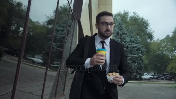 Biznesmen burger jedzenia i picia kawy — Wideo stockowe