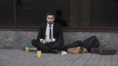 Giyen takım elbise sokakta dilenci adam.