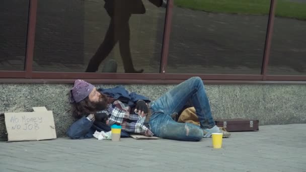 Бизнесмен дает деньги бездомным — стоковое видео