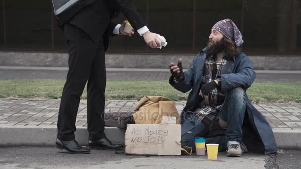 Businessman sharing food to homeless — Stock Video