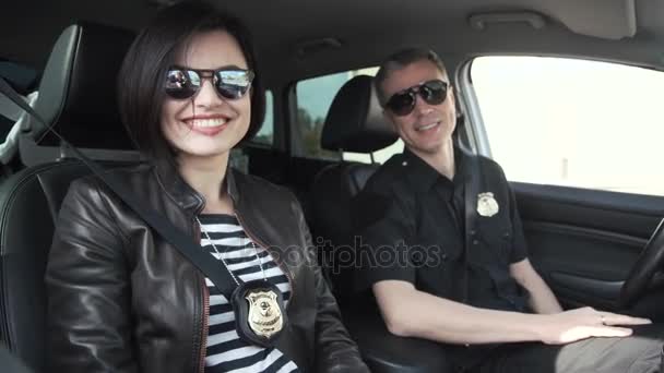 Dos policías sonrientes sentados en el coche — Vídeo de stock