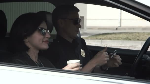 Polizisten trinken Kaffee im Auto — Stockvideo