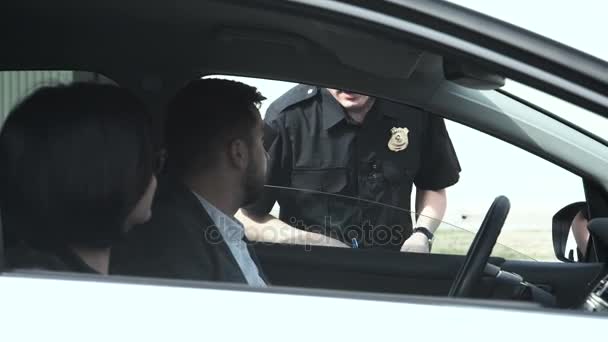 Politieagent stoppen de bestuurder van een voertuig — Stockvideo