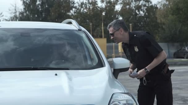 Офицер полиции останавливает водителя автомобиля — стоковое видео