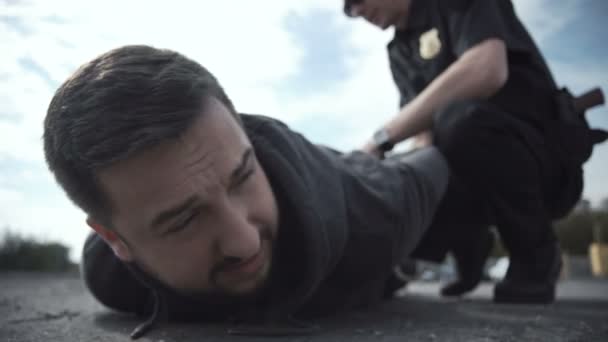 Офицер полиции арестовывает преступника — стоковое видео