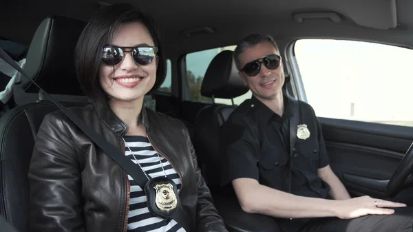 Arabada oturan iki gülümseyen polis memuru — Stok fotoğraf