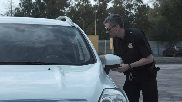 Офицер полиции останавливает водителя автомобиля — стоковое фото