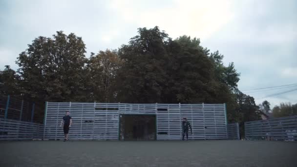 Dos hombres practicando pelota pasando en el campo — Vídeos de Stock