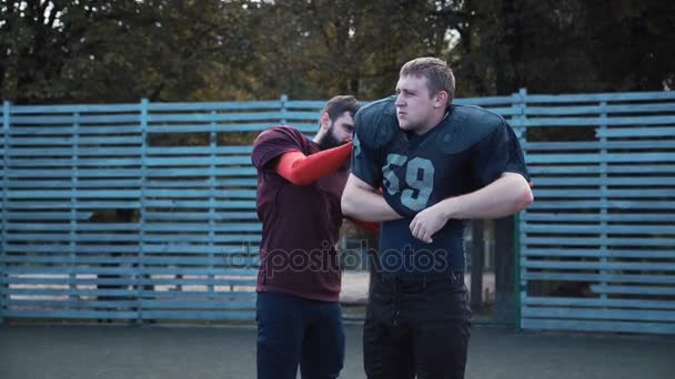 Man helpt zijn partner te zetten op voetbal trui — Stockvideo