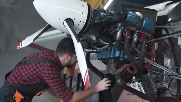 Homem de limpeza do motor da aeronave no hangar — Vídeo de Stock