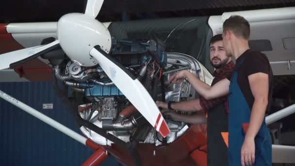 Två mekaniker arbetar på ett litet flygplan — Stockvideo
