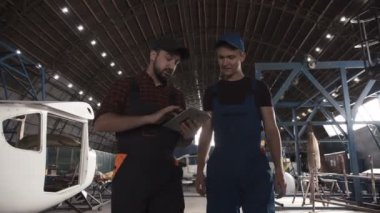 İki adam Uçak hangarında tartışıyor