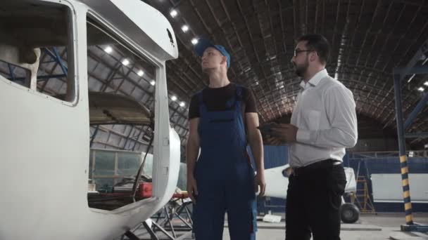 Μηχανικός και συντάκτρια κοντά στο αεροπλάνο του σκελετού — Αρχείο Βίντεο