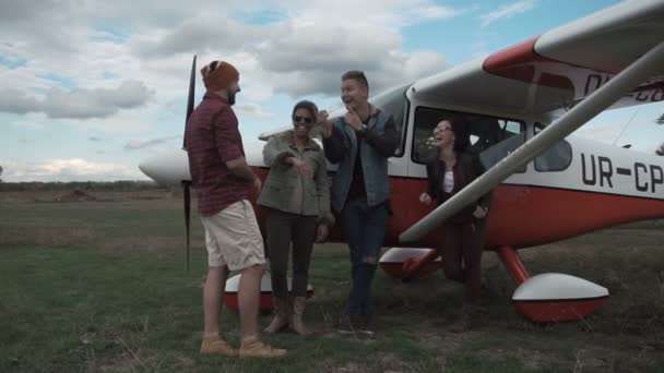 Freundeskreis unterhält sich neben Flugzeug — Stockvideo