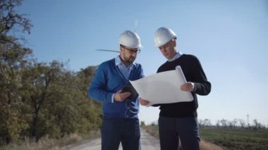 Yel değirmenleri planını tartışıyor mühendisleri