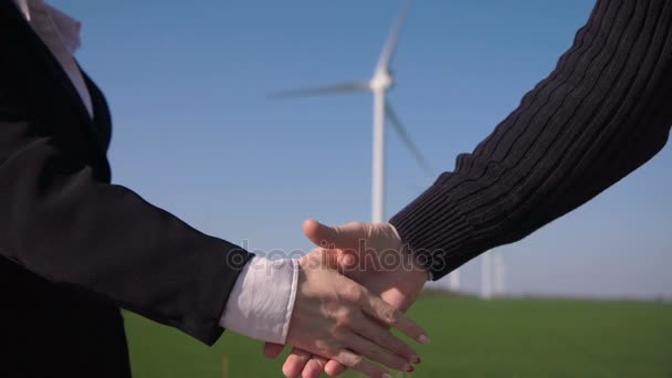 Zakelijke handdruk tegen windturbines — Stockvideo