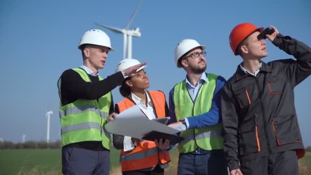 Четыре инженера, стоящие в открытом поле — стоковое видео