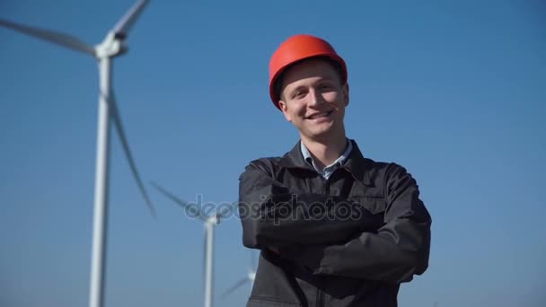 Lachende ingenieur permanent tegen windmolenpark — Stockvideo