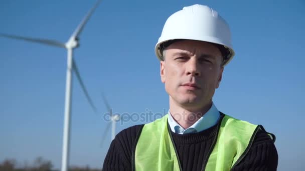 Engenheiro pensativo contra turbina eólica — Vídeo de Stock