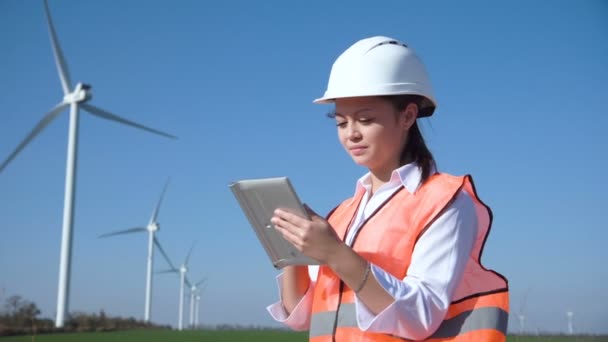 Woman with hard hat against wind turbine — Stock Video