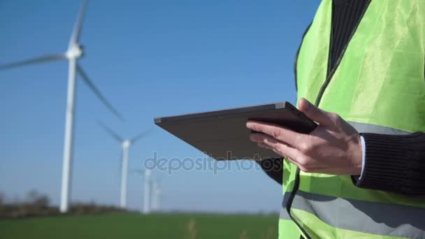 Engenheiro usando tablet digital contra turbina eólica — Vídeo de Stock