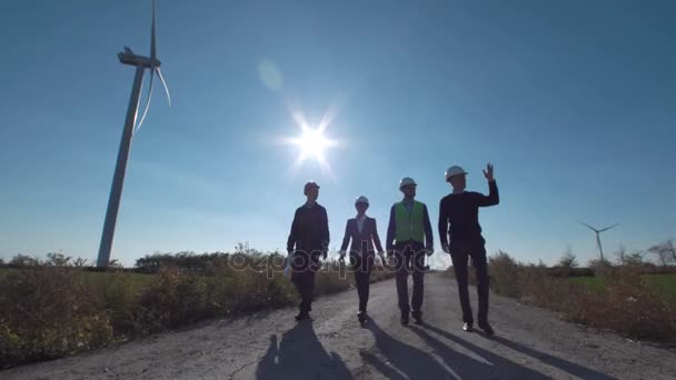 Gruppo di ingegneri che camminano lungo la strada al parco eolico — Video Stock