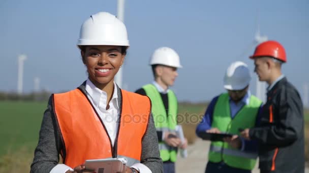 Mujer con casco protector contra turbina eólica — Vídeos de Stock