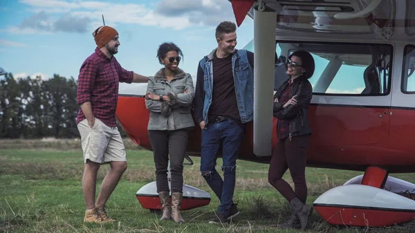 Grupp vänner pratar bredvid flygplan — Stockfoto