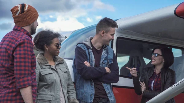 Grupo de amigos hablando al lado del avión — Foto de Stock