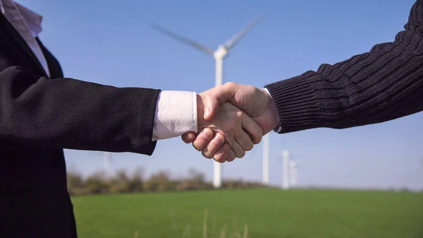 Бізнес рукостискання проти вітрових турбін — стокове фото