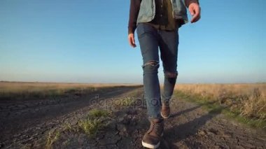 Bilinmeyen uzak kırsal bir yolda yürüyen adam
