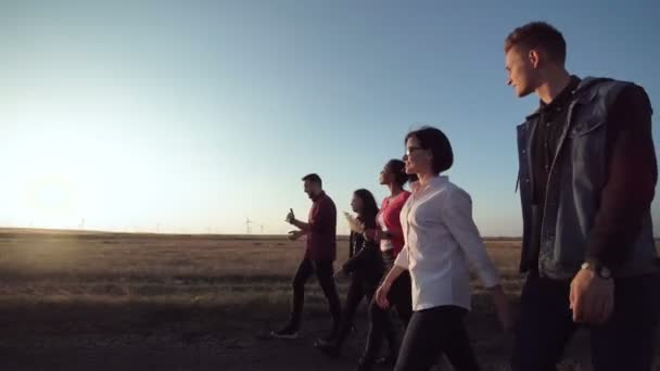 Група з п'яти осіб, що йдуть вздовж брудної дороги — стокове відео