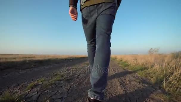 Невідомий чоловік йде по сільській дорозі — стокове відео