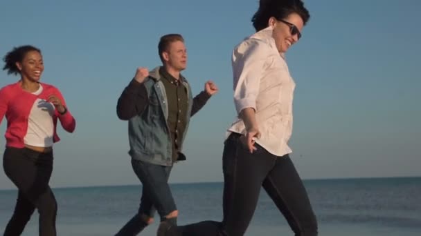Сміється молодь біжить на береговій лінії — стокове відео