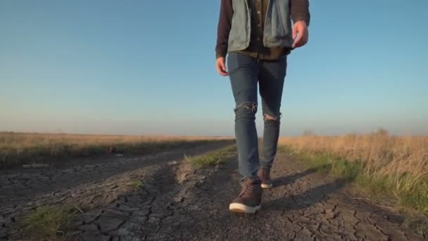 Неизвестный уходит по сельской дороге — стоковое видео