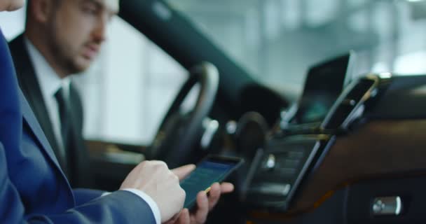 Klient a prodejce připojit smartphone do auta — Stock video