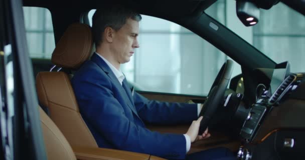 El hombre de negocios se instala sentado en el coche nuevo — Vídeo de stock